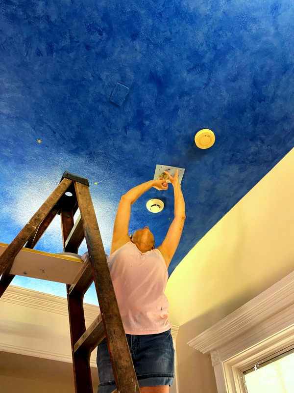 woman putting stars on ceiling