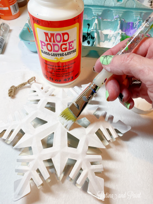 adding Mod Podge to a snowflake
