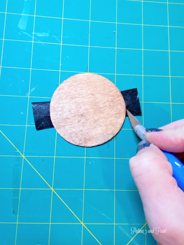 cutting off tape around wooden circle